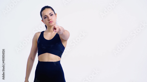 Fototapeta Naklejka Na Ścianę i Meble -  displeased young woman in sportswear pointing with finger and looking at camera isolated on white