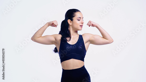 strong sportswoman showing muscles isolated on white