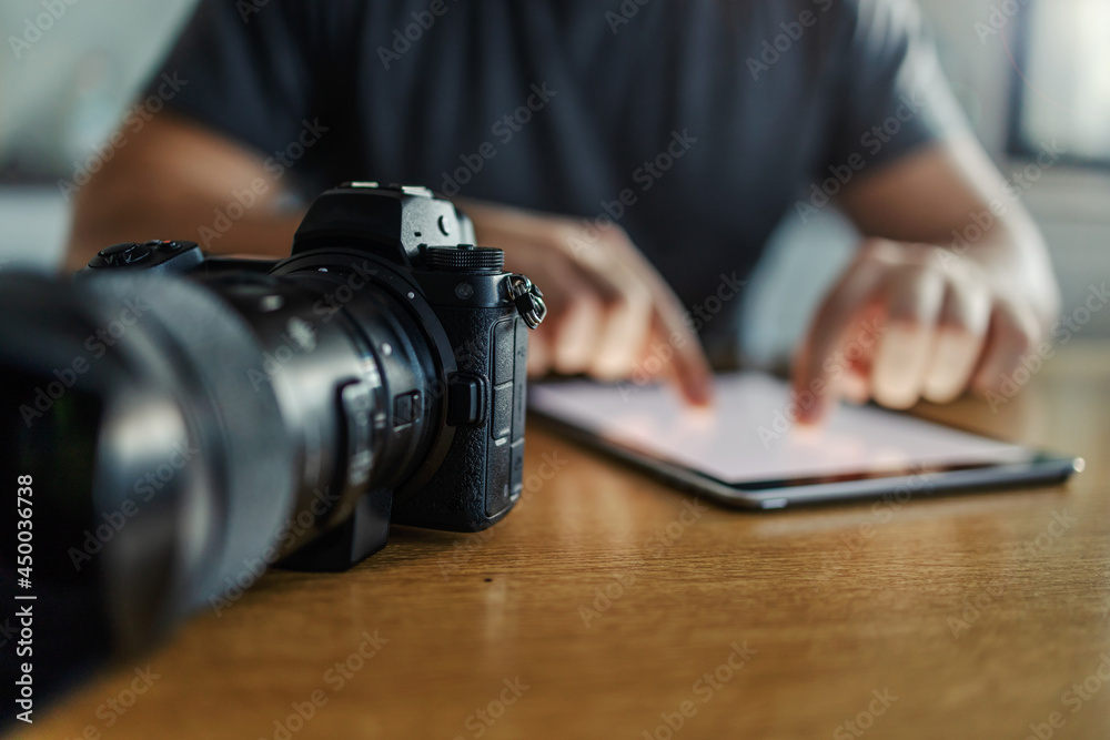The organization, planning, and delegation of work through digital media. The leader of the photographer enters the data into the tablet and sets the camera for the photo shooting The organization, planning, and delegation of work through digital media. The leader of the photographer enters the data into the tablet and sets the camera for the photo shooting