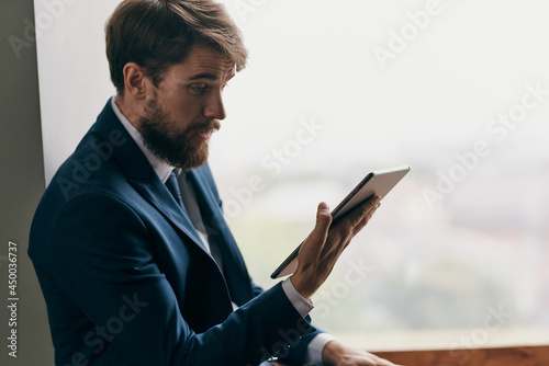 business man near window with tablet in hands communication technology