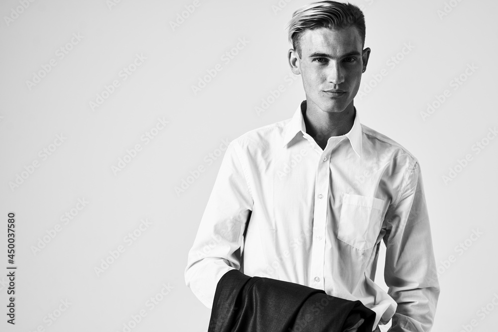 Obraz premium man in white shirt with jacket in hands cropped view light background