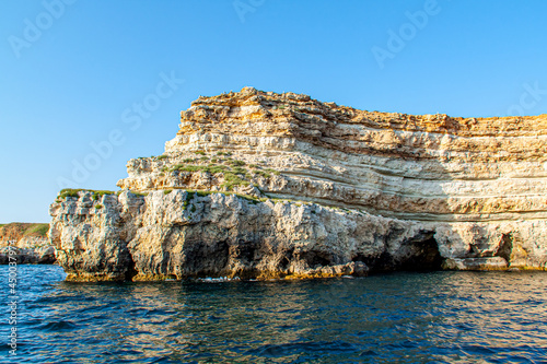 Black Sea orange rocks coastline. Coastal orage rocks and blue sea. Landscape Summer. Traveling. Sevastopol, Crimea, Russia.