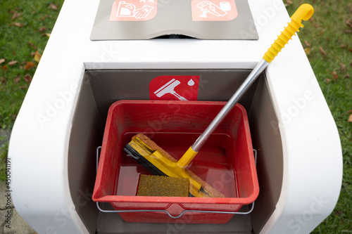 Container for household supplies with a mop photo