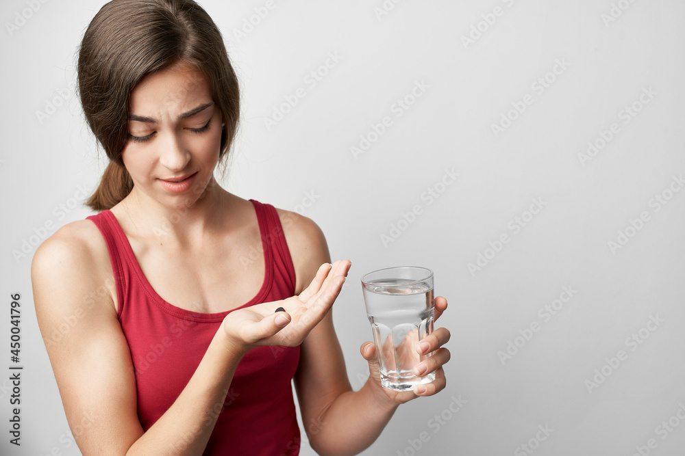 woman in red t-shirt taking pills medicine health problems woman in red t-shirt taking pills medicine health problems