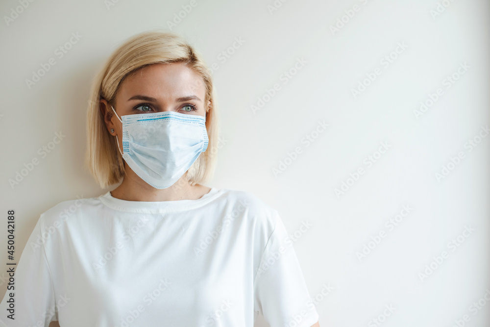 Blonde woman wearing medical mask. Coronavirus health problem. Virus protection. Pollution prevention. Health care. Blonde woman wearing medical mask. Coronavirus health problem. Virus protection. Pollution prevention. Health care.