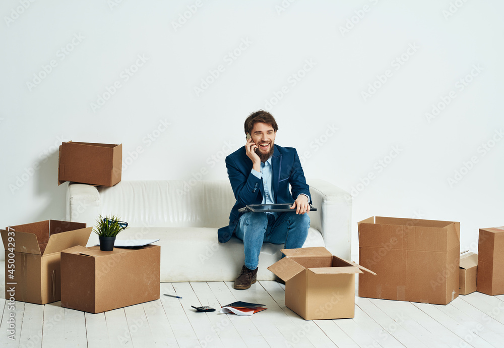 manager sits on a white couch boxes with things moving professional manager sits on a white couch boxes with things moving professional