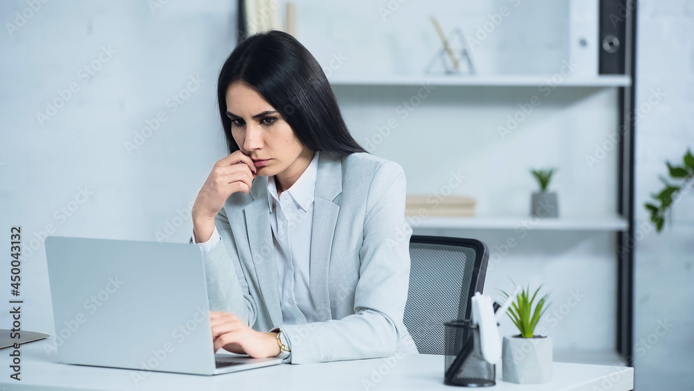 worried businesswoman using laptop in office worried businesswoman using laptop in office