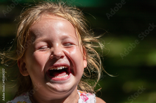 the child is crying and laughing, the child is hysterical photo