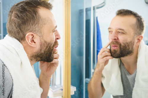 Man looking at his beard in mirror