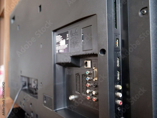 Rear side of black tv set, close up of connection ports panel.