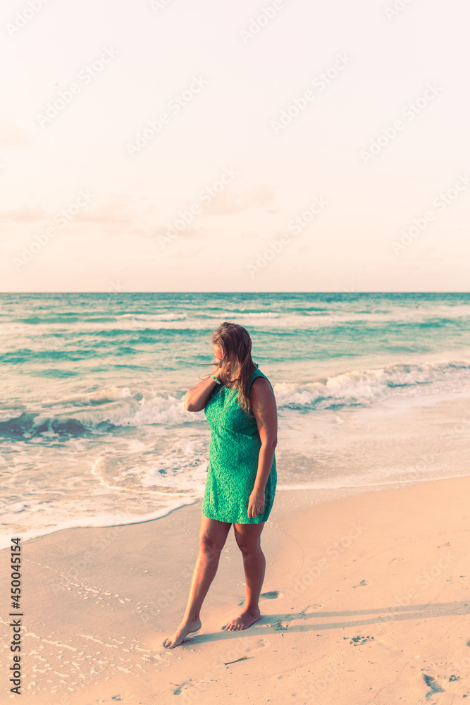 Girl walks along the beach in a dress