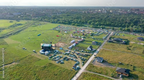 Rest in tents on the background of forest and city, sunset by the river on the field