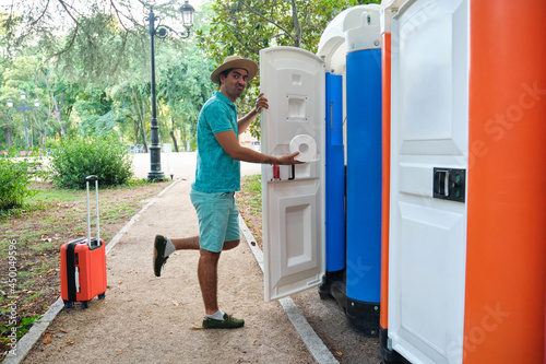 Man taking toilet paper from a portable toilet. photo