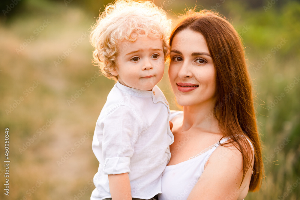 Portrait of a woman with her cute curly-haired son outdoors Portrait of a woman with her cute curly-haired son outdoors