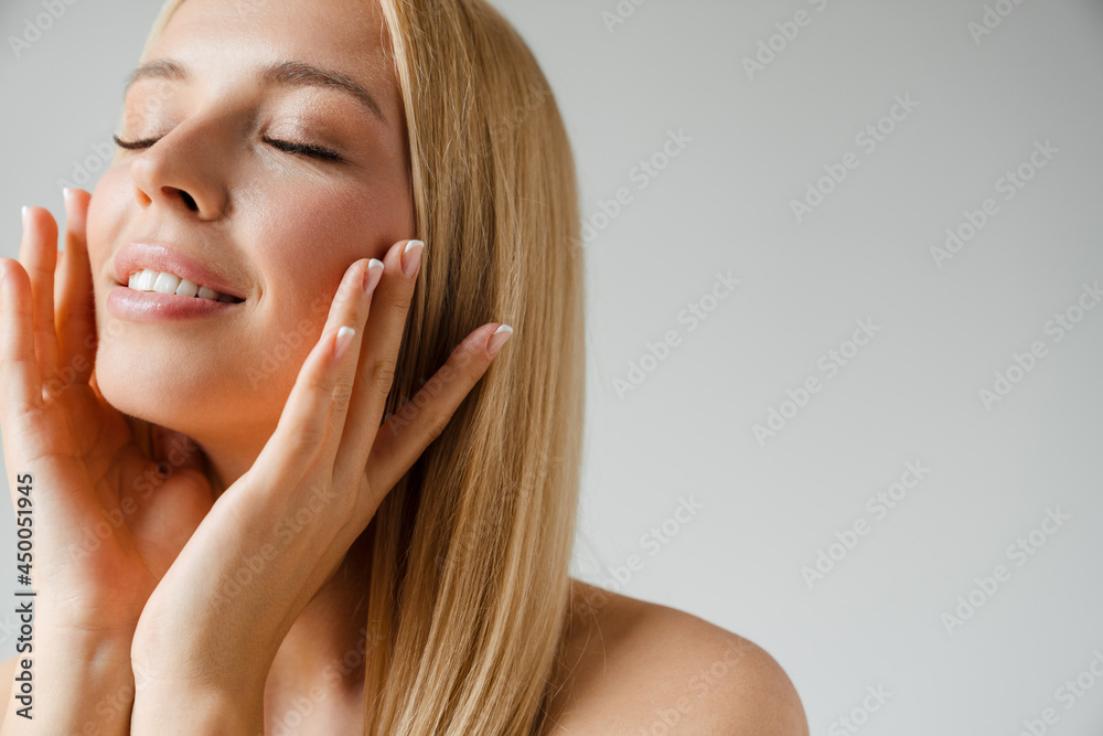 Shirtless blonde woman touching her skin and smiling Shirtless blonde woman touching her skin and smiling