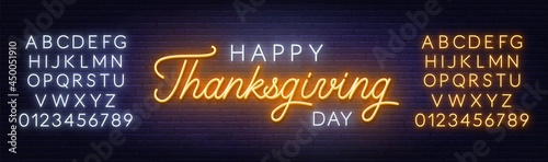 Happy thanksgiving day neon sign. Greeting card on brick wall background
