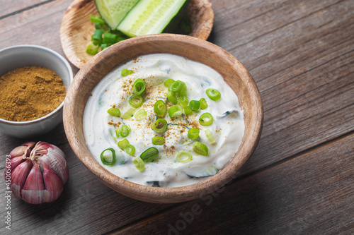 Traditional Indian Raita with Dahi in a bowl on a wooden table