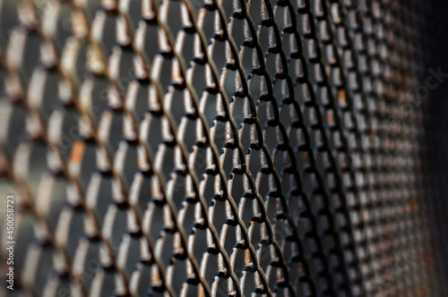 selective focus of dark metal mesh fence