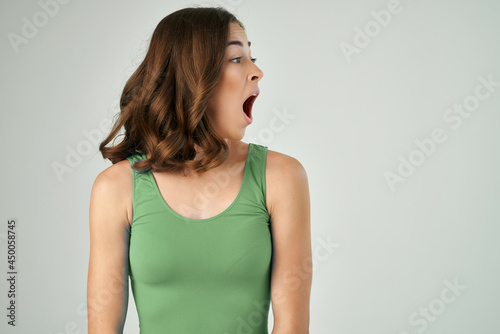 pretty brunette with open mouth in green tank top emotions cropped view
