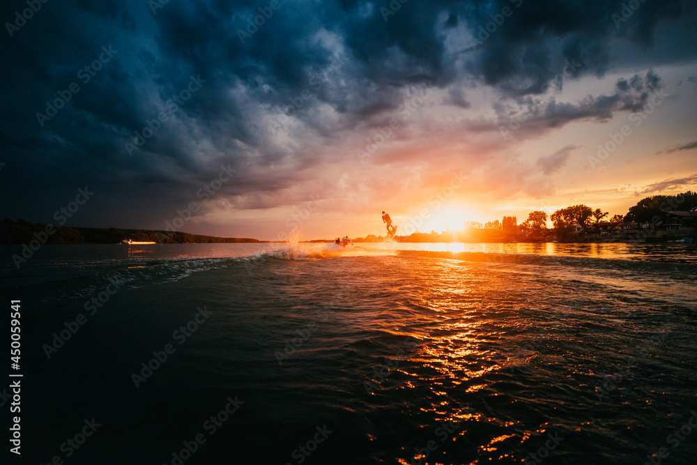 A silhouette of a wake-boarder riding a wave A silhouette of a wake-boarder riding a wave