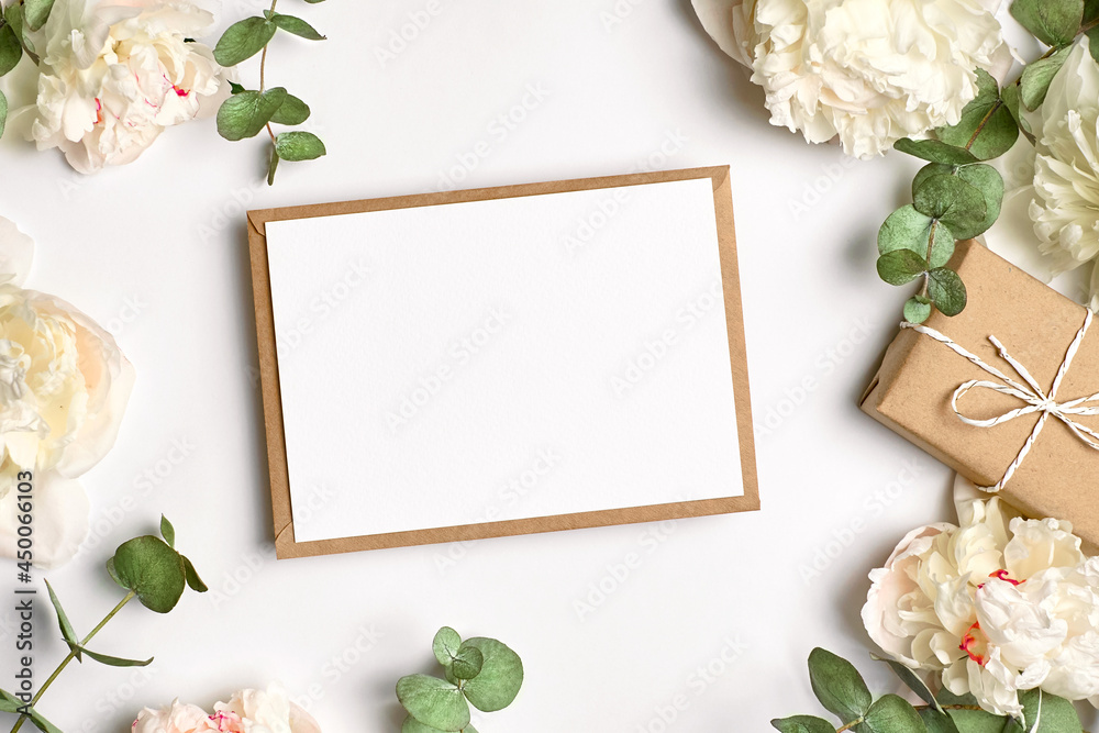 Greeting card mockup with copy space, gift box and white peony flowers and eucalyptus twigs