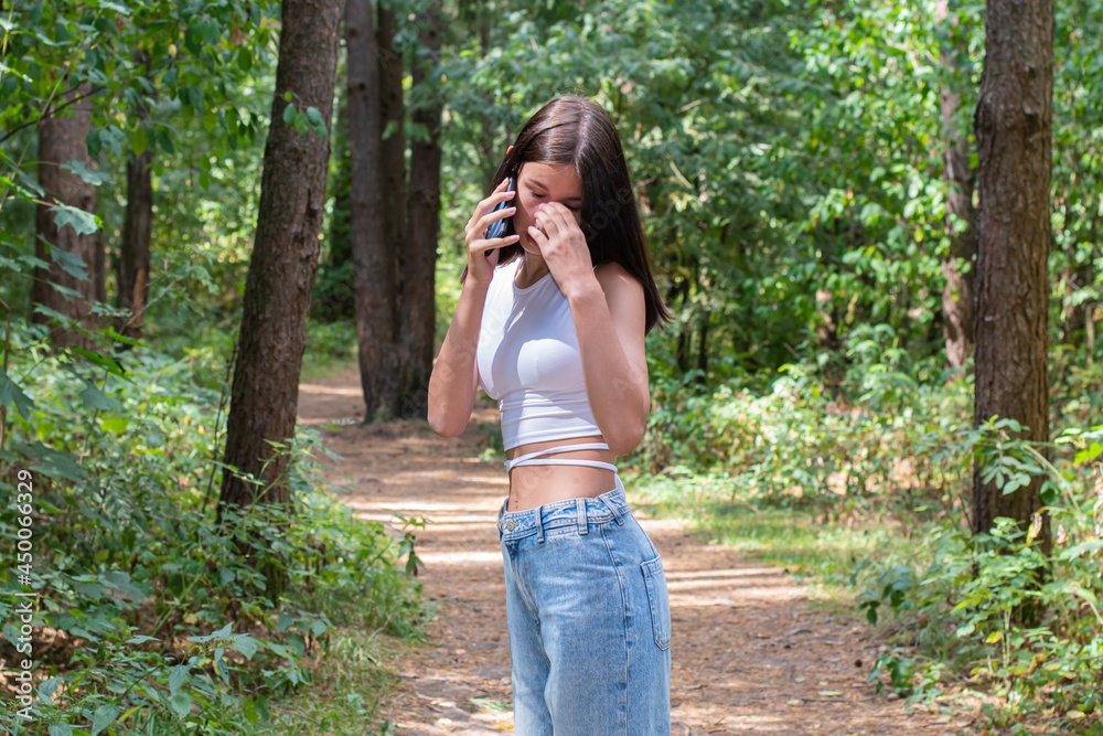A teenage girl walks dreamily through a landscaped park on a beautiful sunny day. A teenage girl walks dreamily through a landscaped park on a beautiful sunny day.