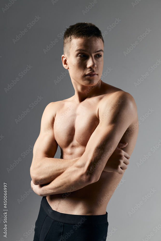 sexy bodybuilder crossed arms over chest on gray background cropped view close-up