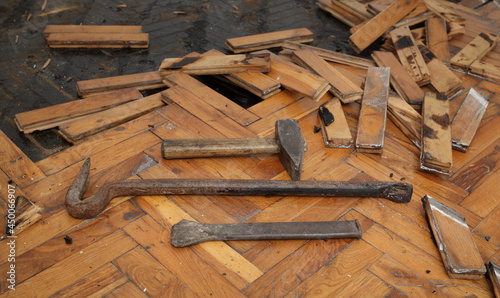 Tools for old damaged parquet removal, hammer, crowbar, chisel at old planks