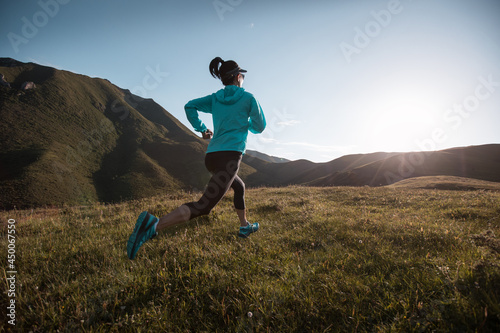 Young woman trail  runner running at mountain top © lzf
