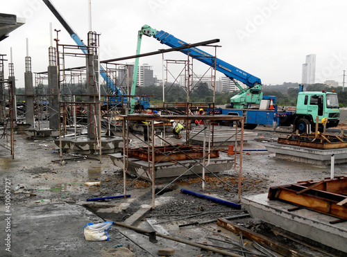 PENANG, MALAYSIA -JUNE 18, 2021: Structural works are underway at the construction site. Construction workers are installing formwork made of metal or timber. Safety features are paramount. 