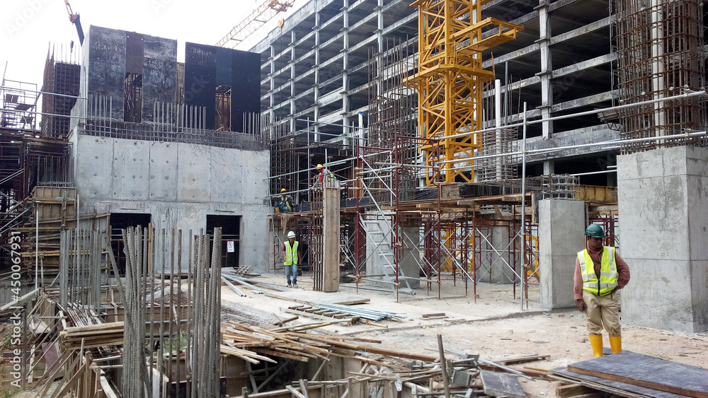 PENANG, MALAYSIA -JUNE 18, 2021: Structural works are underway at the construction site. Construction workers are installing formwork made of metal or timber. Safety features are paramount.
