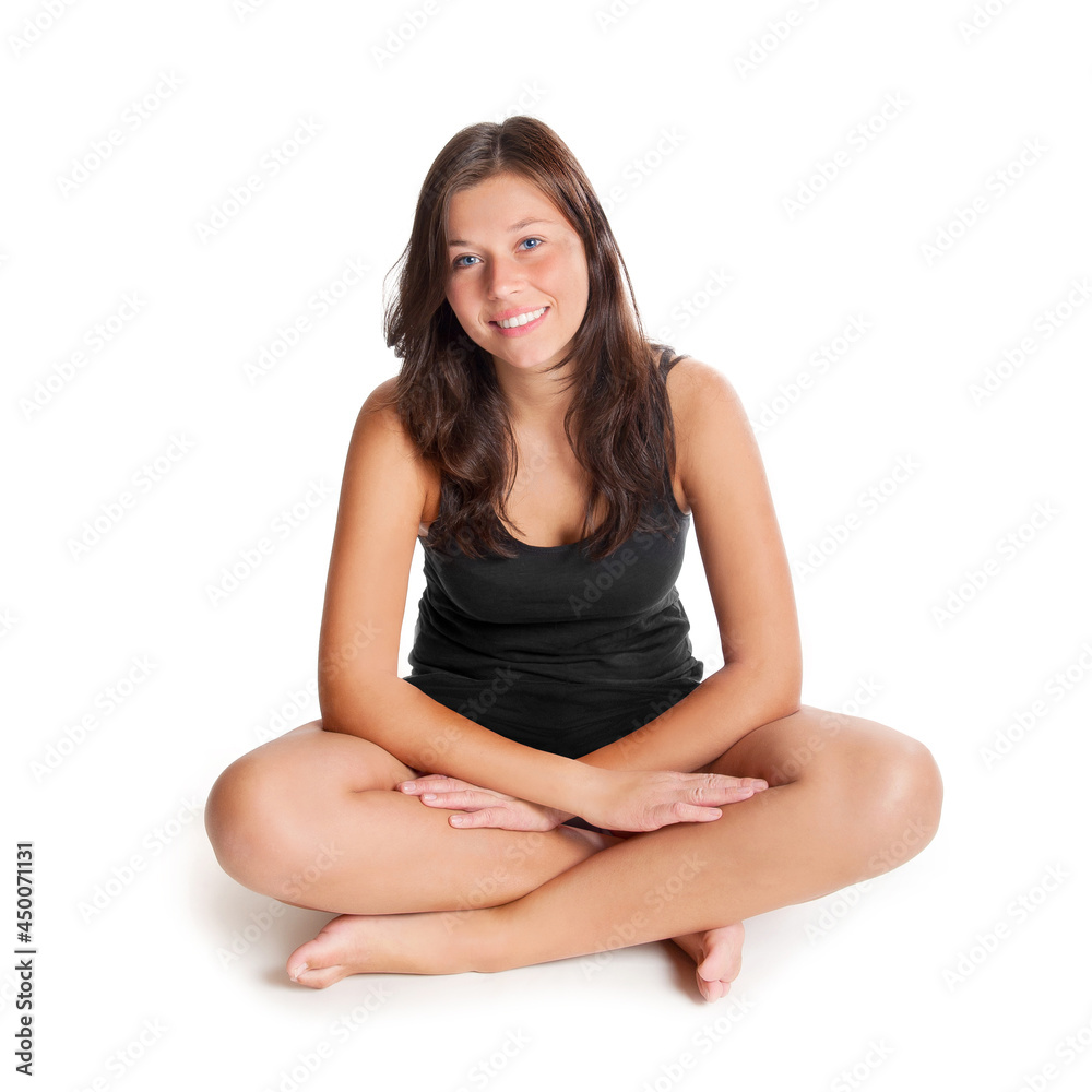 Happy young woman wearing black sportswear, she is sitting in front of white studio background Happy young woman wearing black sportswear, she is sitting in front of white studio background