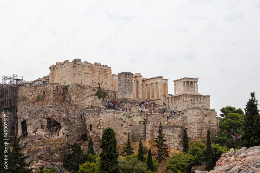Acropolis hill (Parthenon, Temples) in summer cloudy day. Athens ancient historical landmark in city center from Filopappou Hill on cloudy day