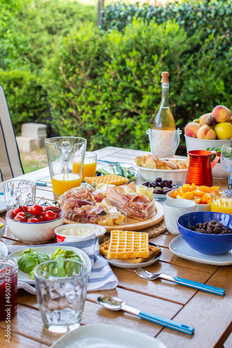 Food on the table.Laid table with food.Breakfast on the terrace.Avocado croutons.Healthy breakfast.Juice is poured for breakfast.The family is eating delicious food.There are many dishes on the table.