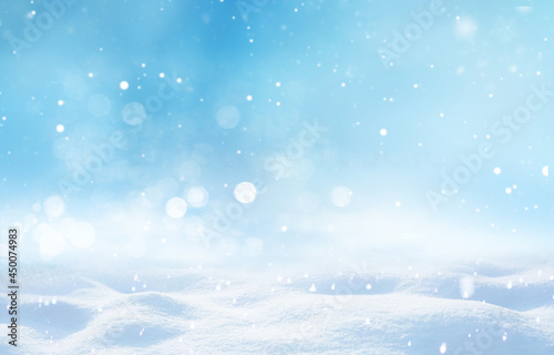 Beautiful light winter snowy background with snowdrifts, sparkling snowflakes, falling small flakes snow with turquoise and blue and white background.