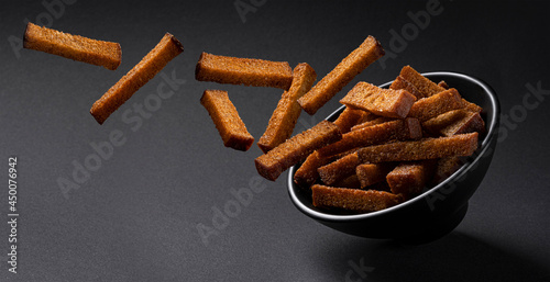 Falling rye croutons on black background