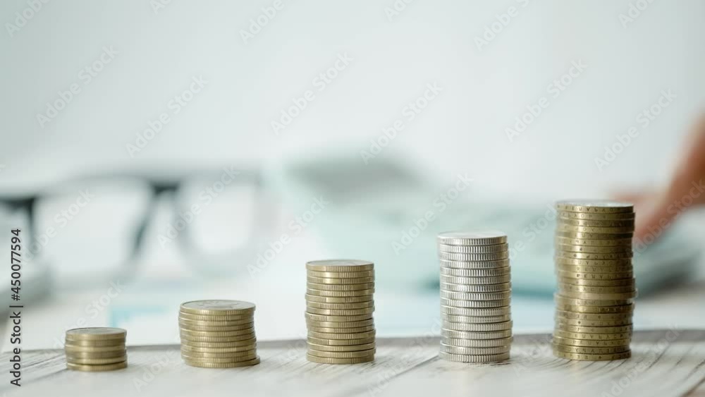 A woman is calculating her expenses for a month. Coins for taxes or payments. Concept of poverty savings money or counting budget and unemployment. Close up A woman is calculating her expenses for a month. Coins for taxes or payments. Concept of poverty savings money or counting budget and unemployment. Close up