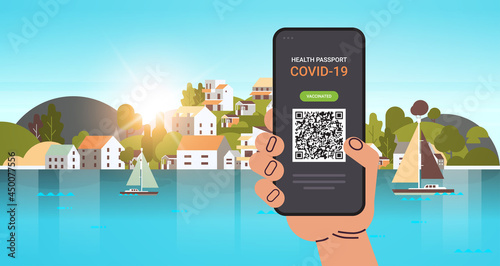 hand using digital immunity passport with qr code on smartphone screen risk free covid-19 pandemic