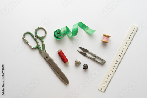 Flat lay composition with scissors and other sewing accessories on light background.