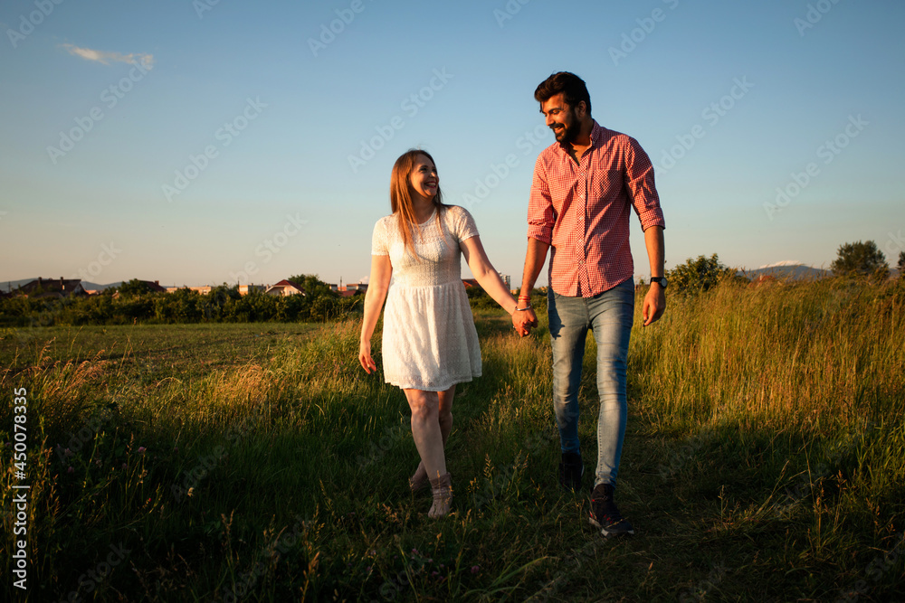 Lovely couple walking in the summer field