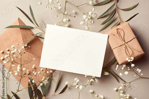 Cuadro en lienzo Invitation or greeting card mockup with envelope, gift box and eucalyptus and gypsophila twigs