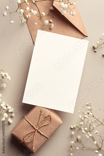 Invitation or greeting card mockup with gift box and gypsophila plant twigs