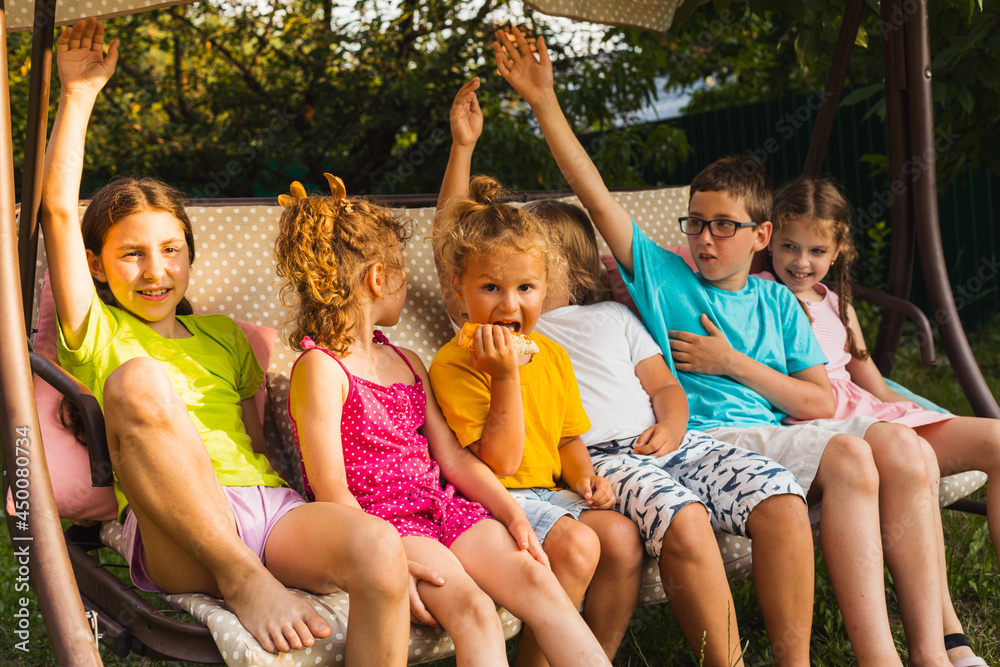 Fototapeta premium Children sitting on large swing in backyard