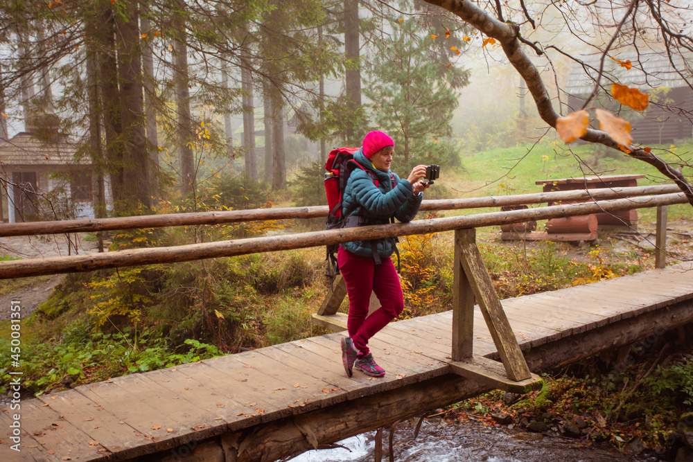 Woman is taking a selfie while hiking in the forest Woman is taking a selfie while hiking in the forest