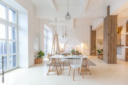 Fashionable modern interior of a light studio apartment with wooden columns in the loft style  decorated with brick  marble and wood with stylish furniture and white walls