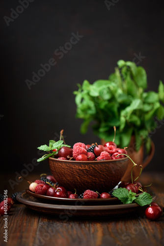 Close-up colorful berries and mint. Assorted mix of raspberry  blackberry  gooseberry and sweet cherry. Selective focus