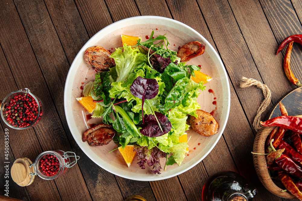 Salad with roasted duck greens and oranges mix on a wooden background Salad with roasted duck greens and oranges mix on a wooden background