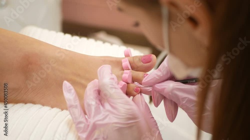 Close up of pedicure applying nail polish on toenails.