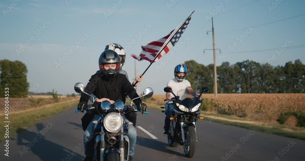 Young people travel on motorcycles with the U.S. flag Young people travel on motorcycles with the U.S. flag
