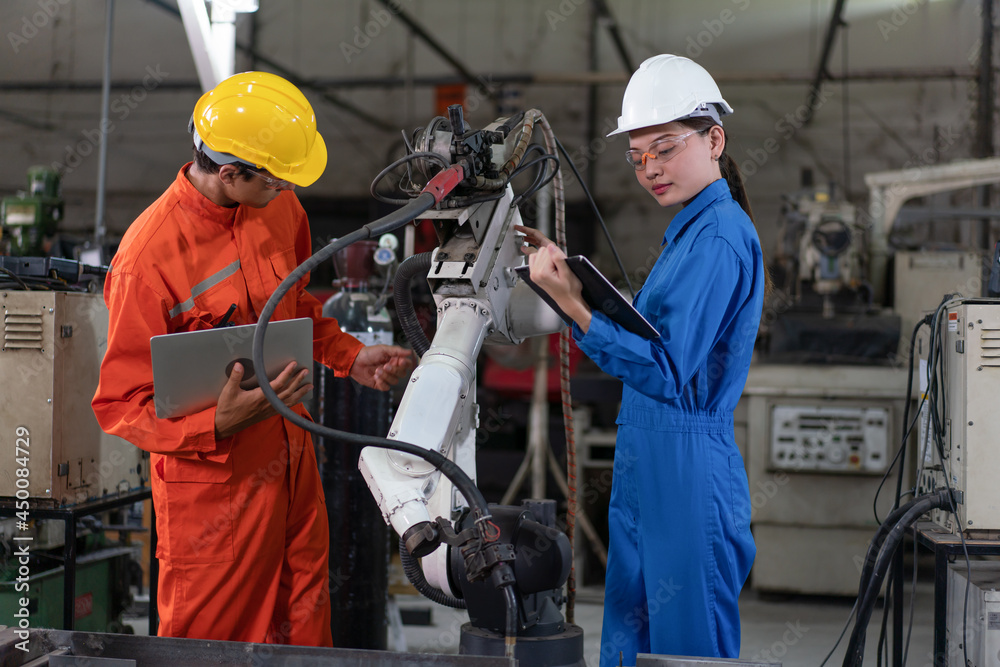 Male and female automation engineers wear a uniform with helmet safety ...